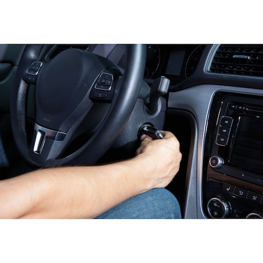 BLACKDECKER BC25 car interior, closeup of hand starting vehicle with ignition key, angled view.