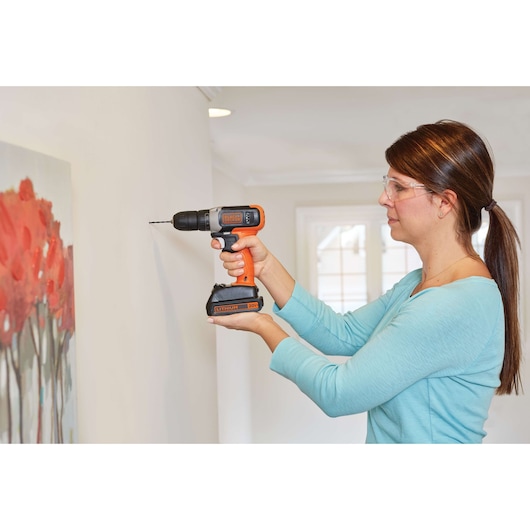 Photo of BLACKDECKER BCD702PK2B cordless drill being used to drill into a wall indoors.
