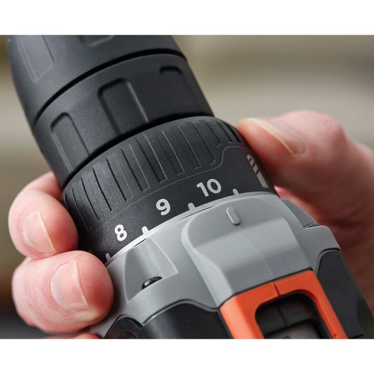 Close-up photo of BLACKDECKER BCD703C1 cordless drill clutch being adjusted by hand, showing numbered torque settings.