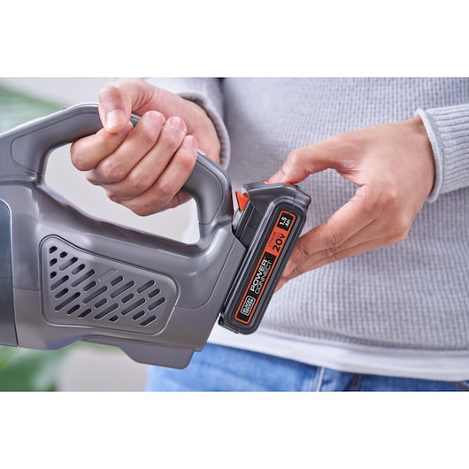 Photo of BLACKDECKER BCHV001D1E handheld vacuum being fitted with 20V lithium battery, close-up view.