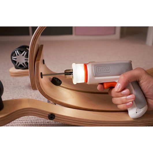 BLACKDECKER BCRTA01 cordless screwdriver with LED light assembling wooden furniture, close-up view.