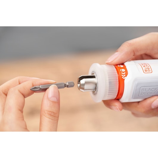 Photo of BLACKDECKER BCRTA01 screwdriver with metal bit held near the chuck in close-up view.