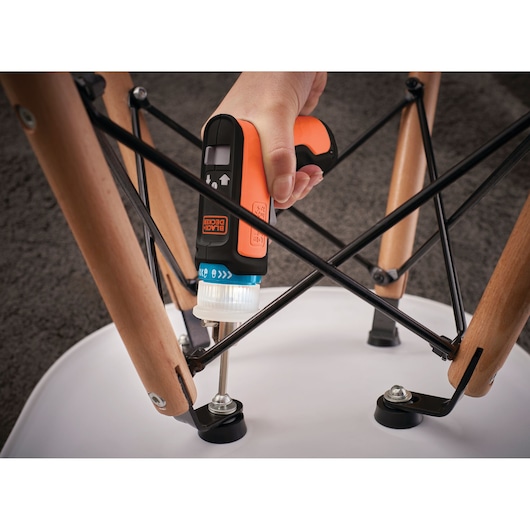 BLACKDECKER BCRTA601I cordless screwdriver used to assemble chair legs on a carpeted floor.
