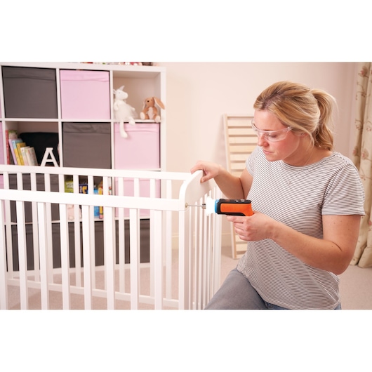 BLACKDECKER cordless screwdriver BCRTA601I fastening crib rail in nursery setting.