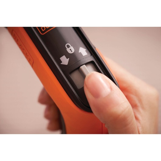 BLACKDECKER BCRTA601I orange handle close-up with thumb on lock switch, product photography.