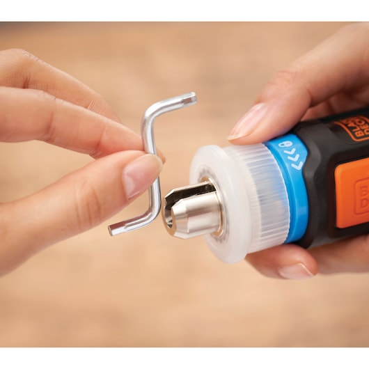 BLACKDECKER BCRTA601I rotary tool close-up with hex key held near metal chuck.