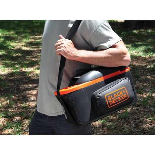 Photo of a person carrying a BLACK+DECKER BDC8-LA portable cooler bag with shoulder strap outdoors.