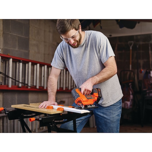 Photo of BLACKDECKER cordless jigsaw BCK22S1S in use on wood in workshop setting.