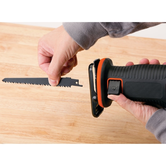 Photo of BLACKDECKER BDCR20C reciprocating saw with user installing blade on wooden surface.