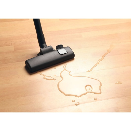 BLACKDECKER BDWD15 vacuum cleaner head on light wood floor, cleaning water spill, top view.