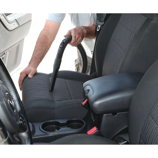 BLACKDECKER BDWD20 vacuum cleaner nozzle cleaning car seat upholstery, photo taken inside vehicle.