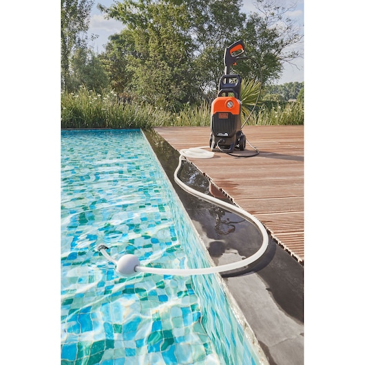 Photo of BLACKDECKER BEPW2200 pressure washer on wooden deck with hose in a swimming pool, outdoor setting.