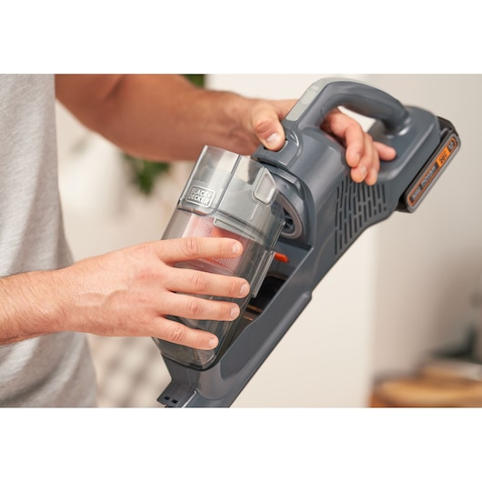 Photo of BLACKDECKER BHFEA18D1 cordless vacuum cleaner, close-up of hand removing dust container.