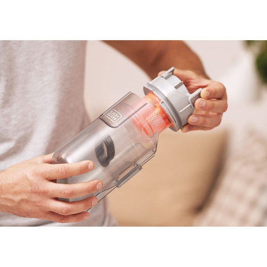 Photo of BLACK+DECKER BHFEA18D1 vacuum cleaner dust container being opened by hand.