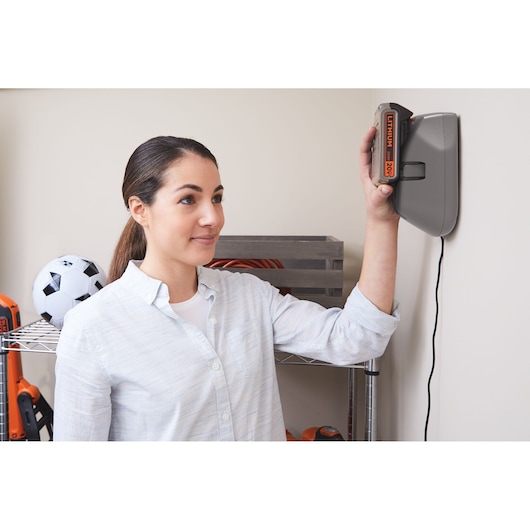 BLACKDECKER BSV20PET handheld vacuum battery charging on mounted wall station in a home setting.
