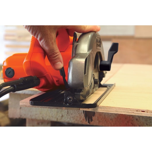 Photo of BLACKDECKER circular saw CS1004 cutting light wood, hand on orange and silver tool body.
