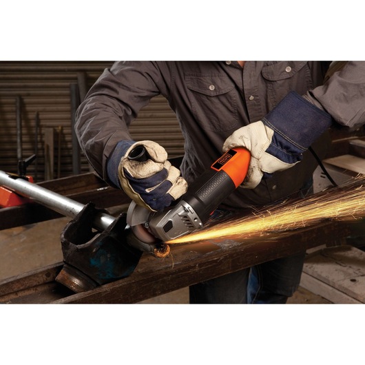 Photo of BLACKDECKER G720 angle grinder in use, sparks flying while cutting metal with operator in gloves.