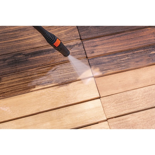 BLACKDECKER PW1450TD pressure washer nozzle cleaning wooden deck, close-up photography.